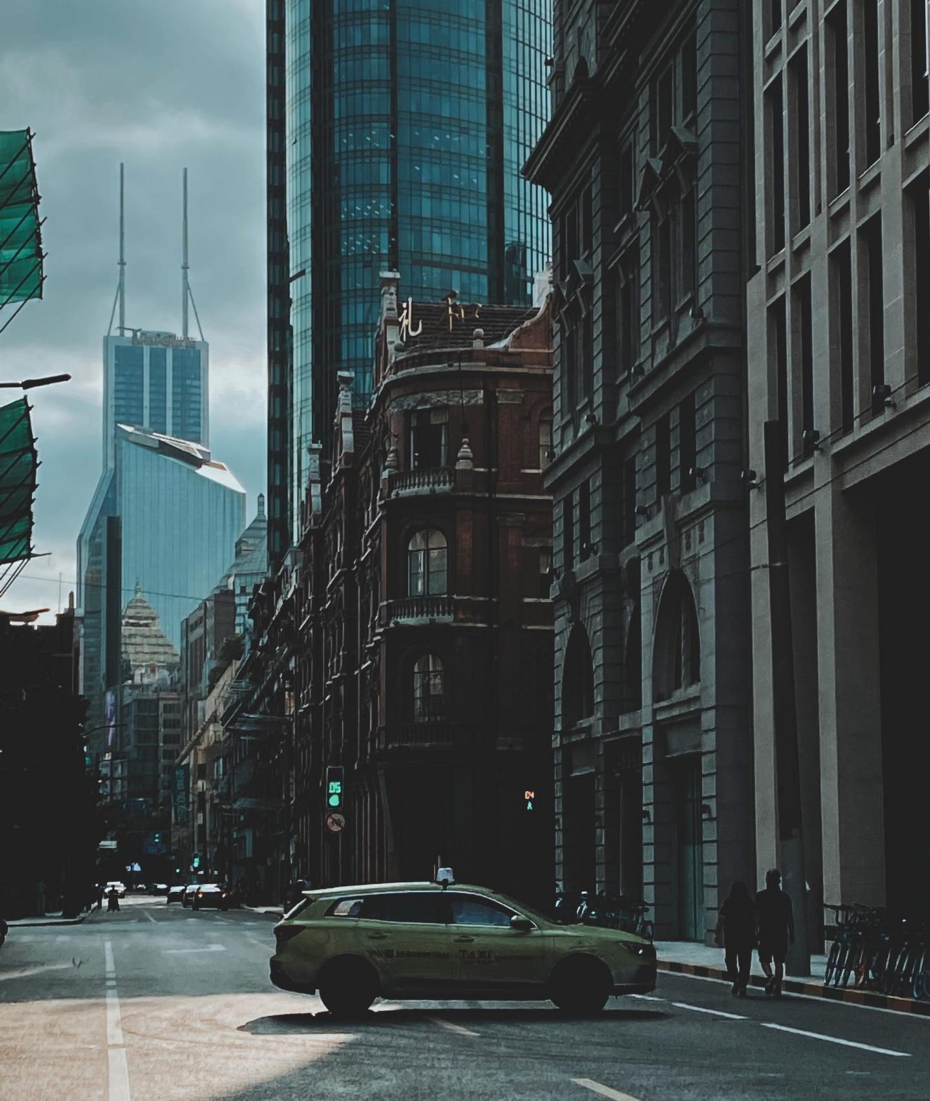 Old Shanghai brick against new glass, a taxi crossing